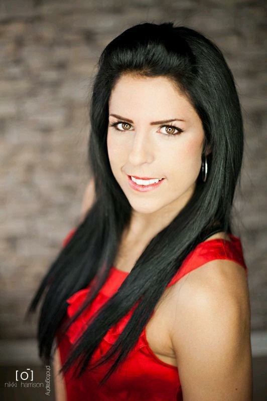 Headshot of a woman with long dark hair wearing a red sleeveless blouse. Headshot of a woman with long dark hair wearing a red sleeveless blouse.