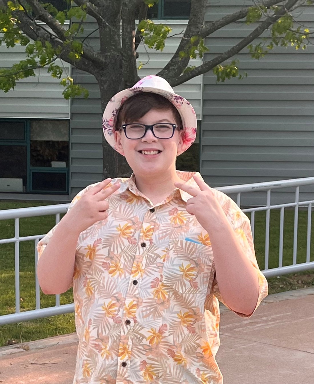Gabe posing with his hands in peace signs outside. 