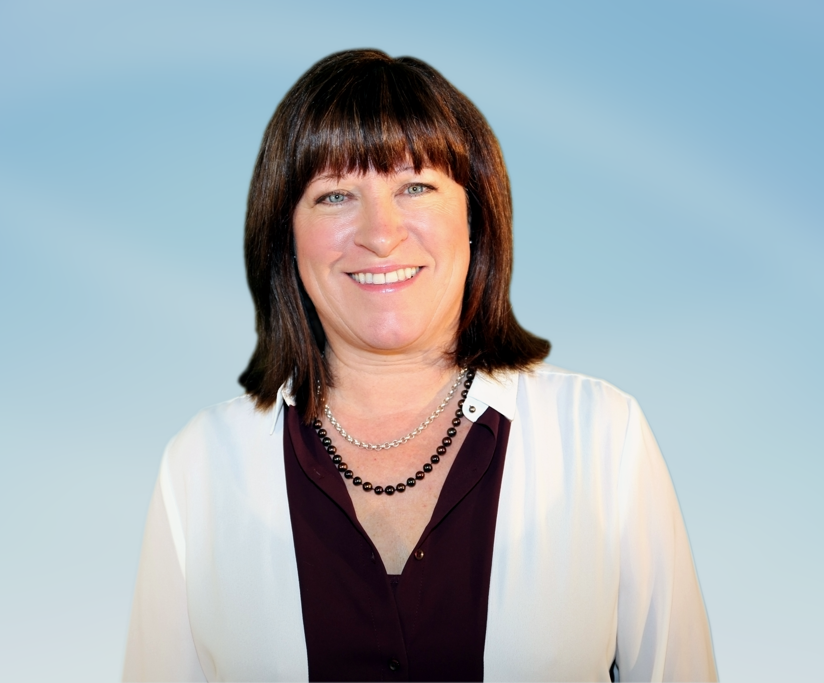 Woman with black blouse and white blazer. She is wearing two necklaces - a black beaded and a silver chain. She is smiling at the camera. Woman with black blouse and white blazer. She is wearing two necklaces - a black beaded and a silver chain. She is smiling at the camera.