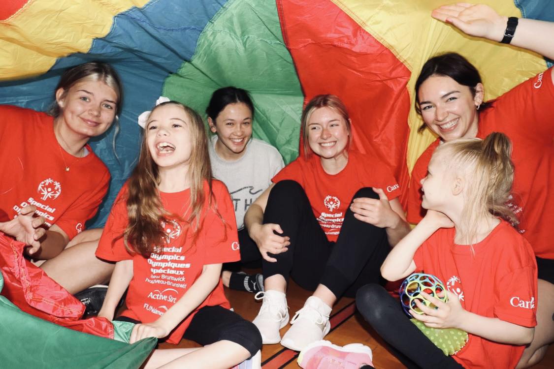 Sophia and group playing under a parachute.