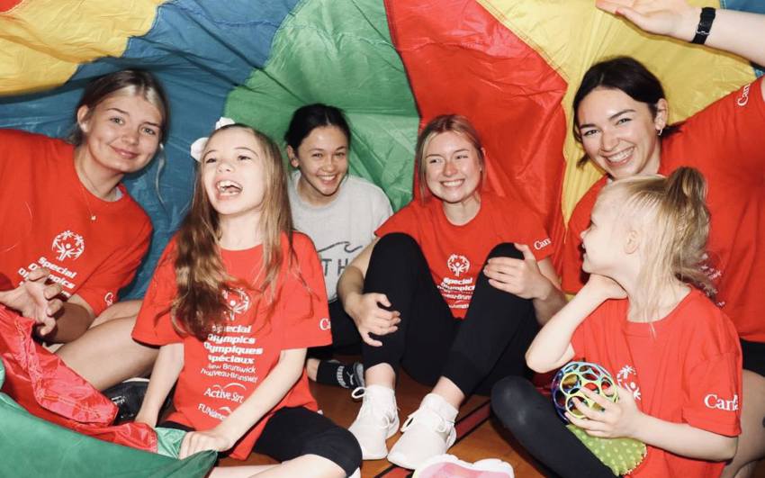 Sophia and group playing under a parachute.