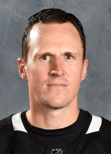 Man with dark hair wearing a hockey jersey. 