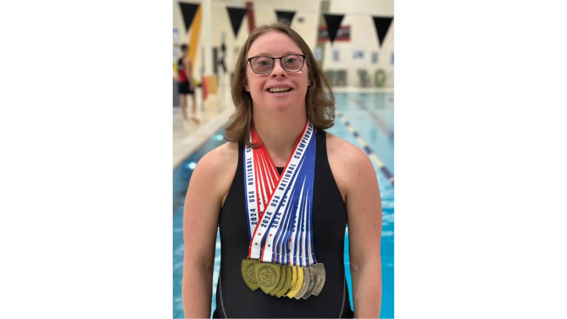Lindsay Reimer with multiple medals standing by a pool.