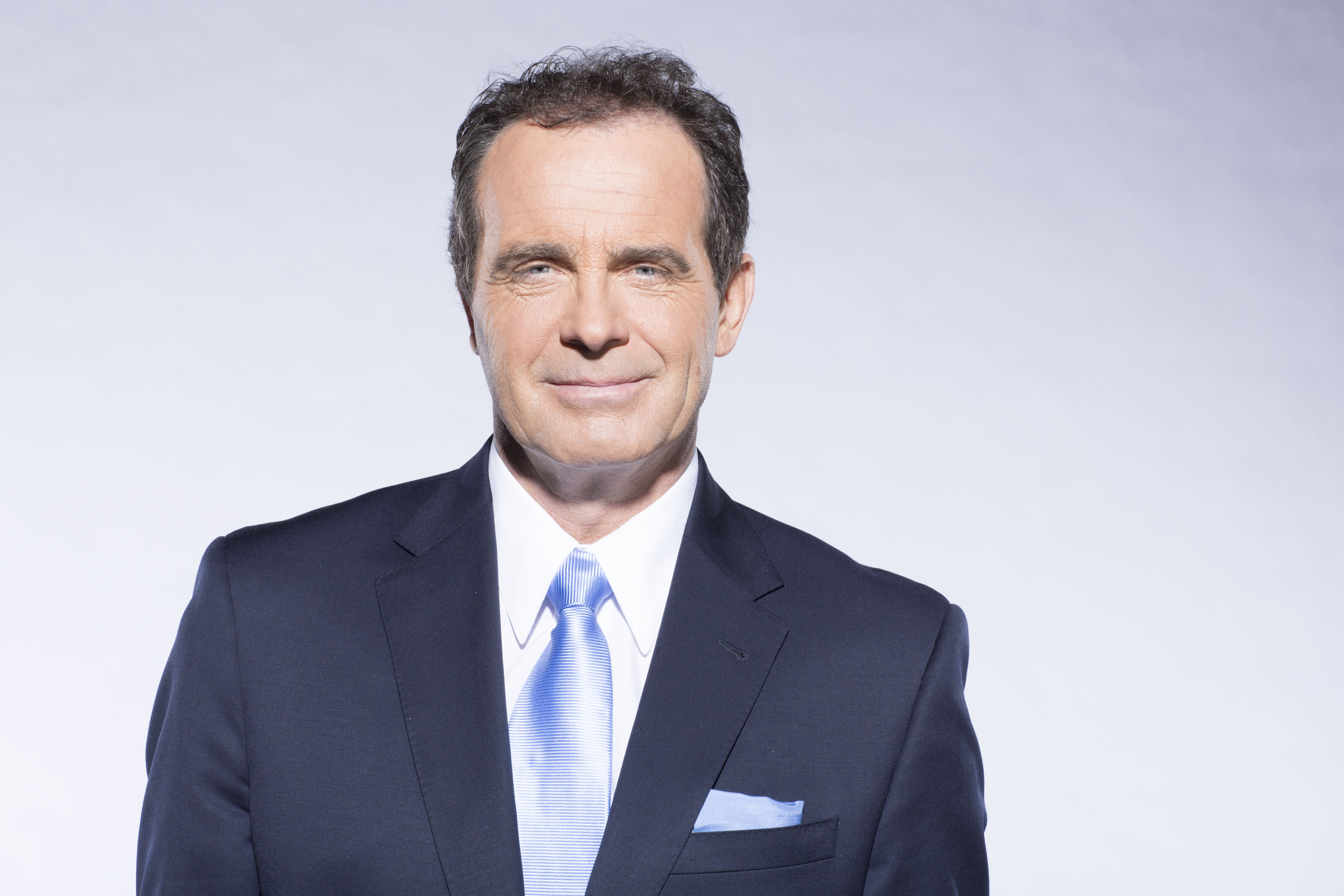 Headshot of a man with dark hair wearing a blue suit, white shirt and blue tie. Headshot of a man with dark hair wearing a blue suit, white shirt and blue tie.