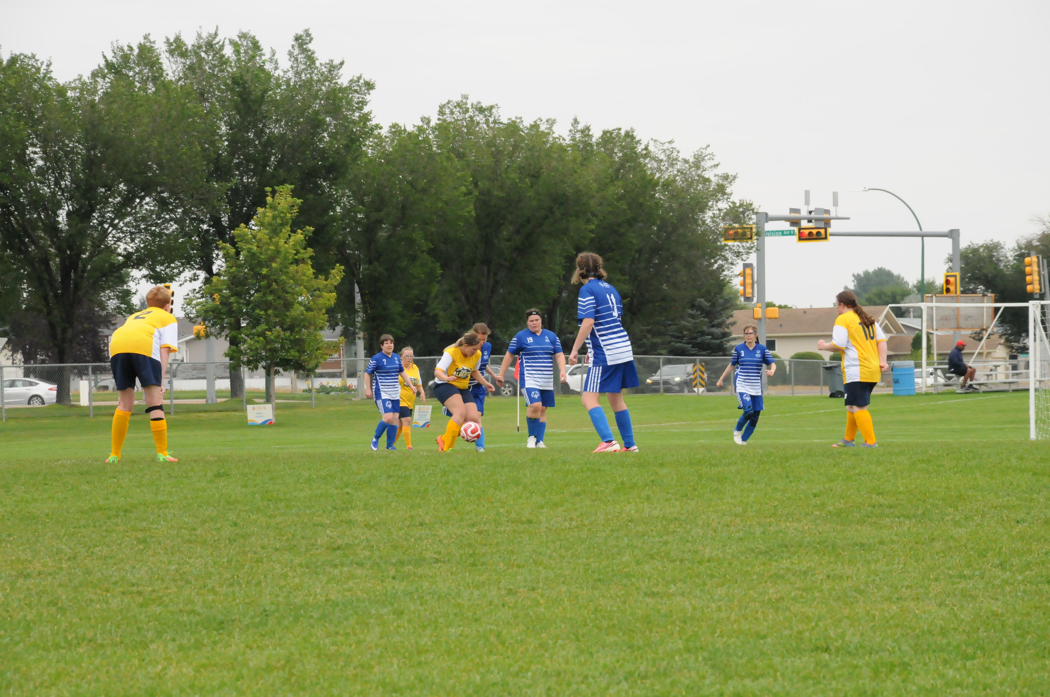 An action shot photo of a women's soccer match. Players are on the field and playing soccer. The two teams are yellow verses blue, which is indicated by their soccer uniforms. An action shot photo of a women's soccer match. Players are on the field and playing soccer. The two teams are yellow verses blue, which is indicated by their soccer uniforms.