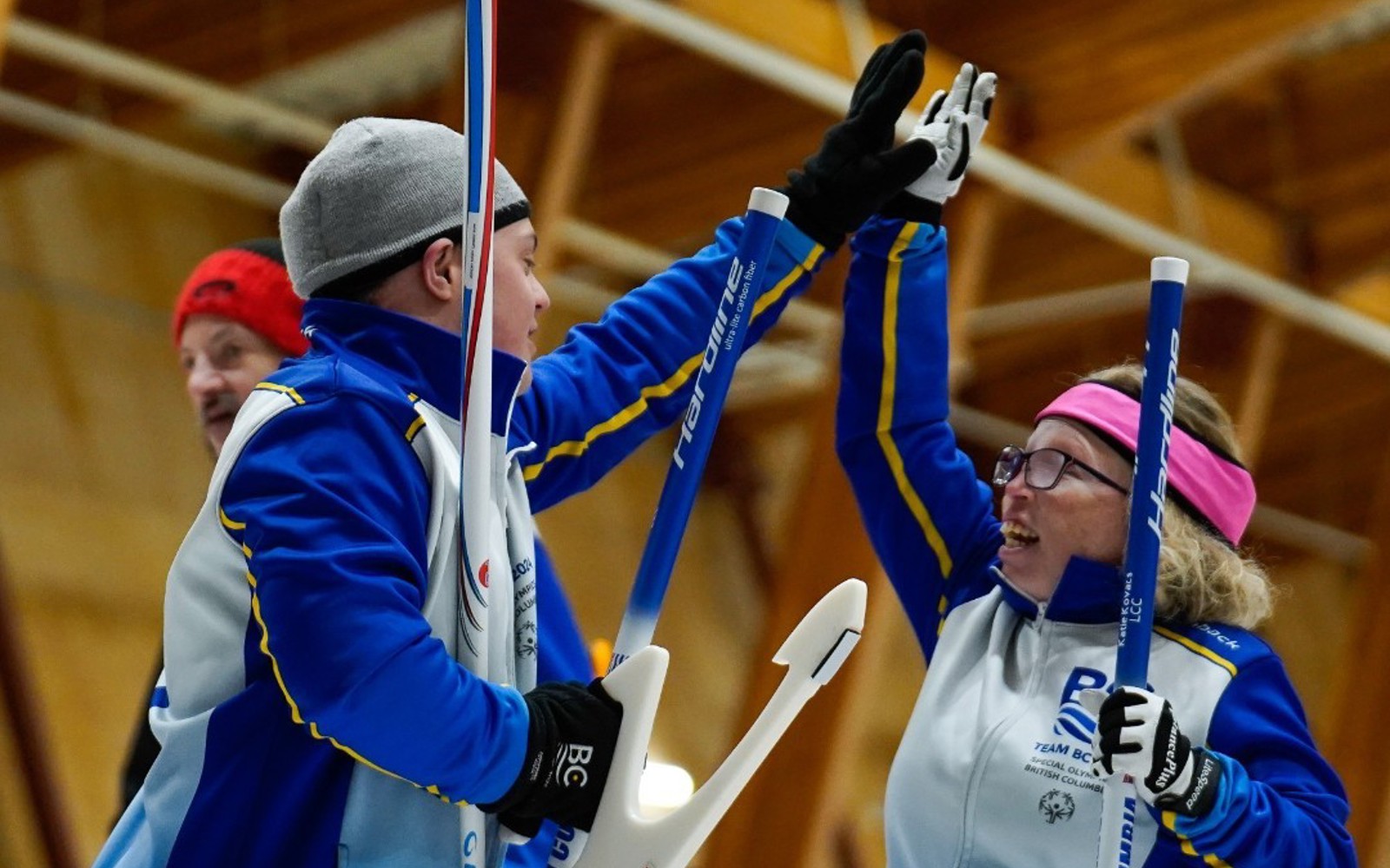 Two Special Olympics BC curling athletes celebrate with a jubilant high-five.