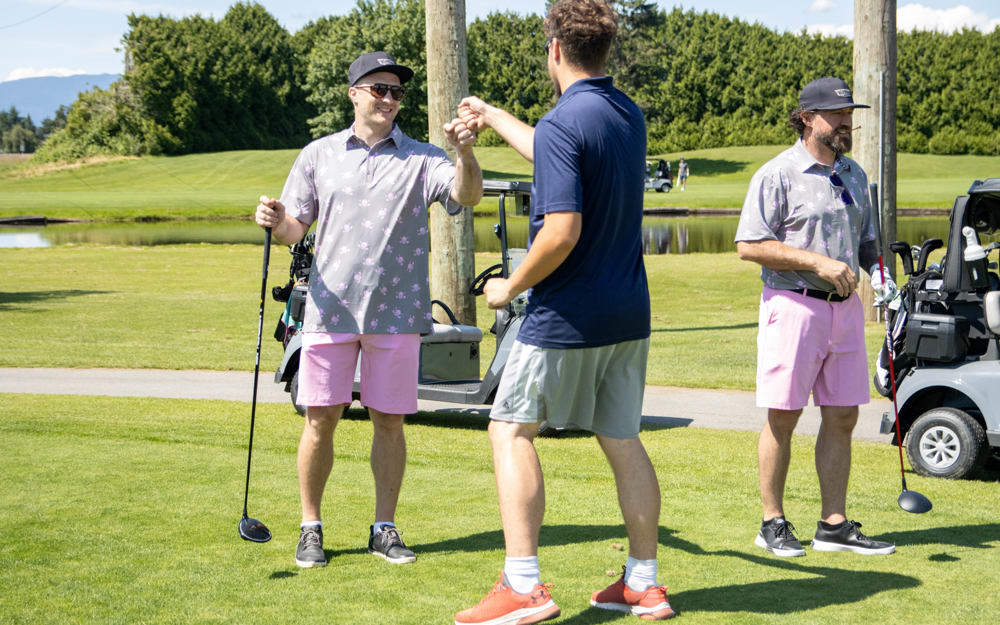 SOBC athlete gives a fist bump to a player on the greens.