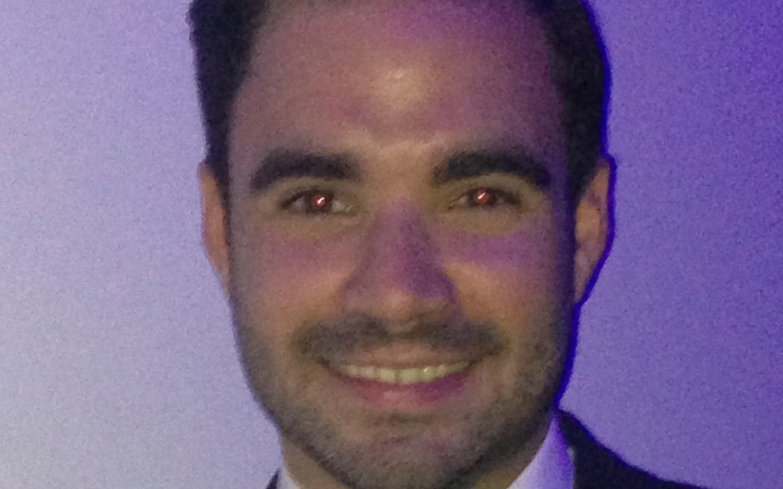 Gros plan sur un homme vêtu d'une veste noire, d'une chemise blanche et d'un nœud papillon noir.