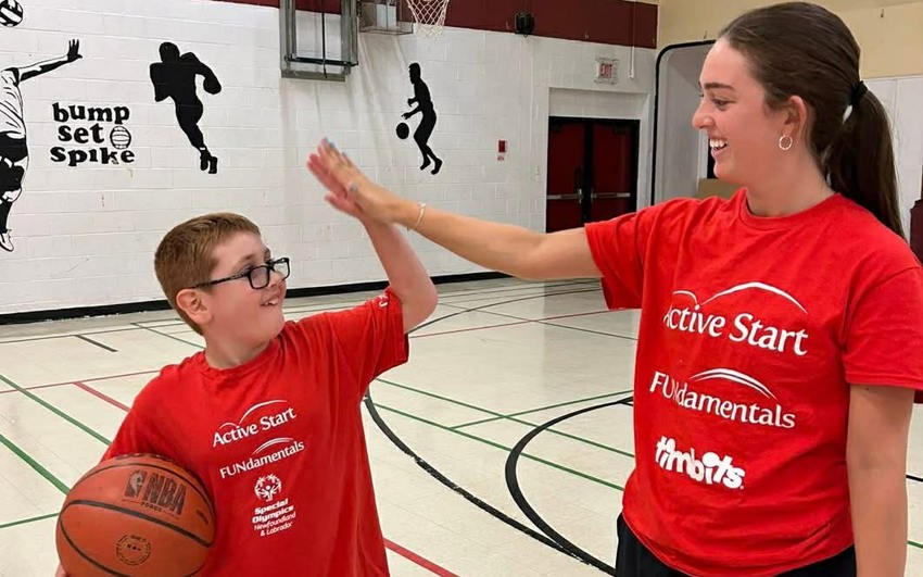 Alexander high-fiving a volunteer. 