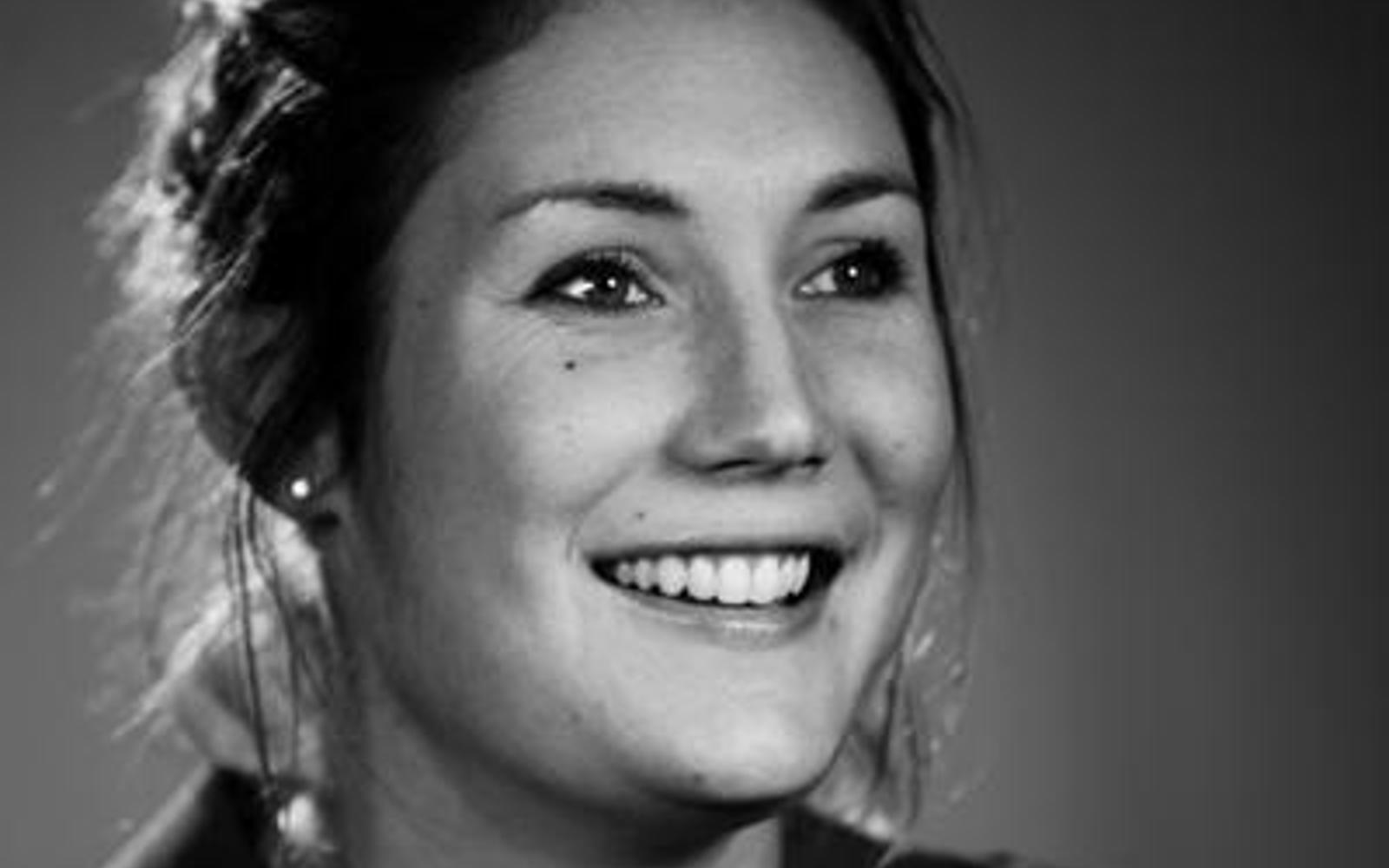 Gros plan sur une femme souriant à la caméra.