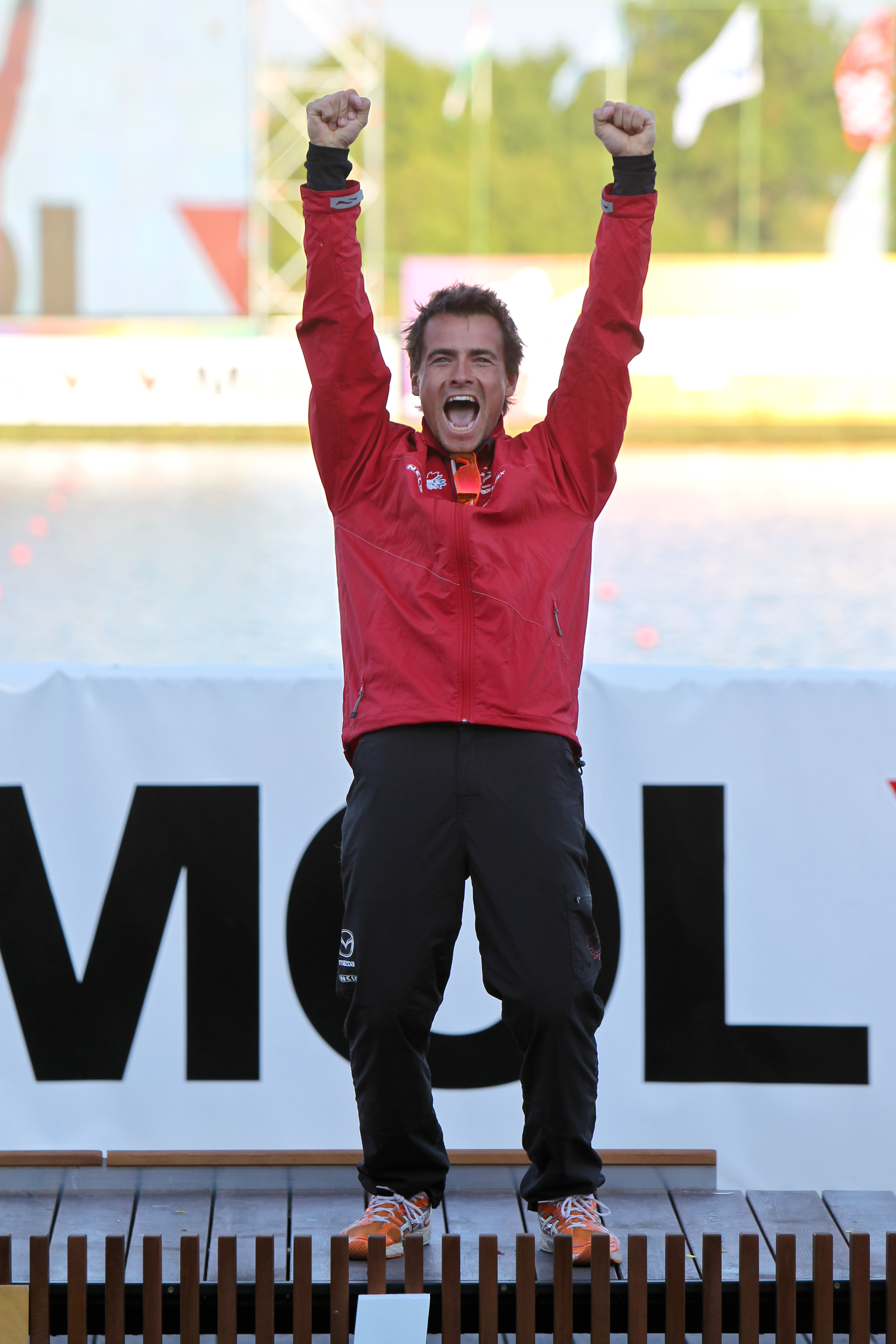 Man in red coat and black pants with his arms in the air cheering. Man in red coat and black pants with his arms in the air cheering.