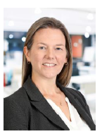 Woman with long blond hair wearing white dress shirt and black blazer. 