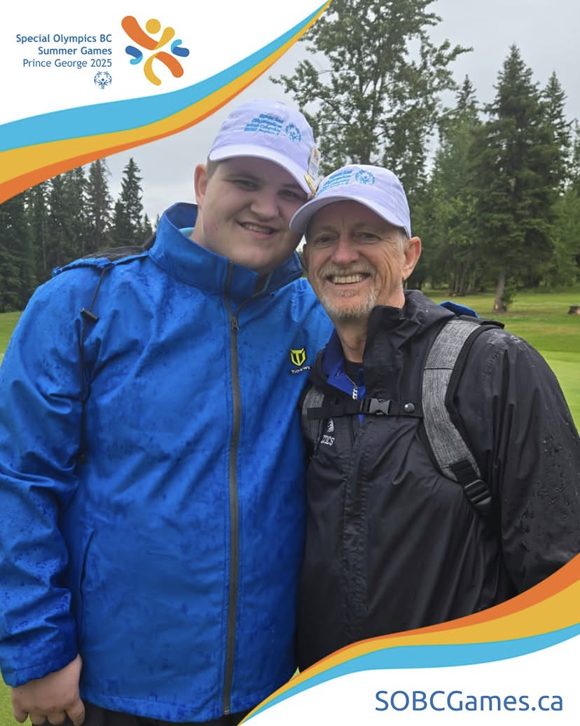 Hayden and Andrew Metcalf pose for a photo outside with matching Special Olympics British Colombia hats on. 