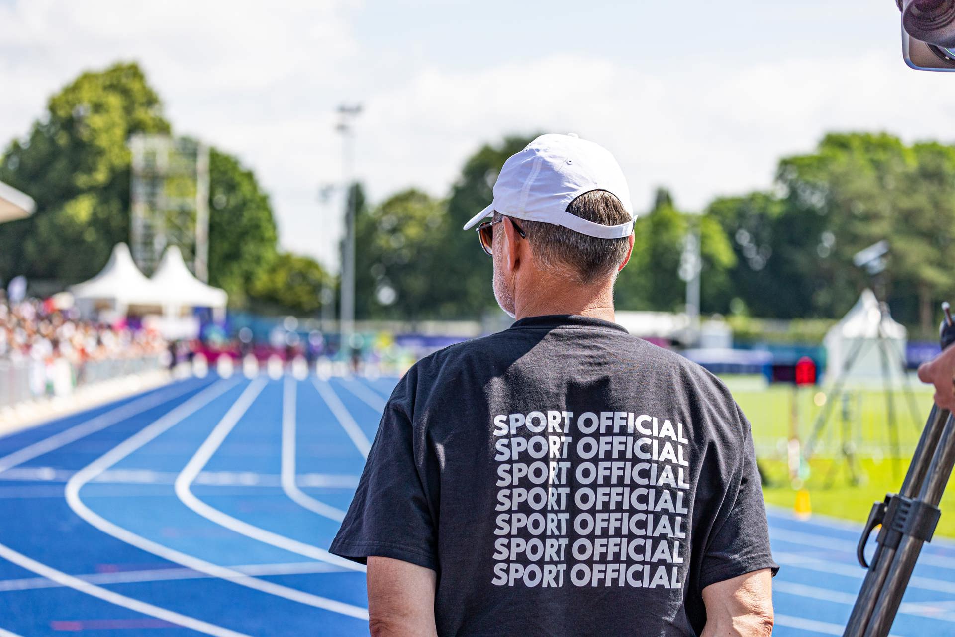 Homme en chemise de sport officielle noire sur un hippodrome