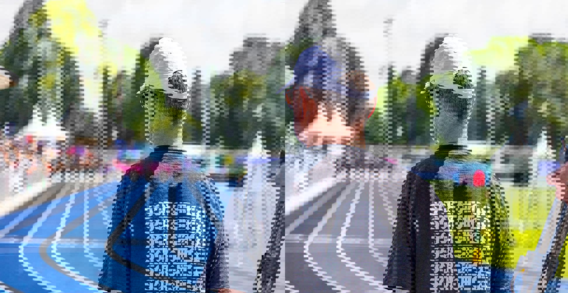 Homme en chemise de sport officielle noire sur un hippodrome