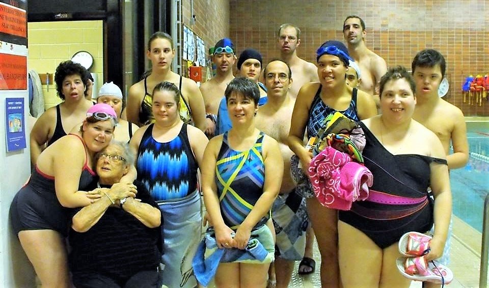 Noella Douglas takes a photo with the Laval swim team at a local pool.