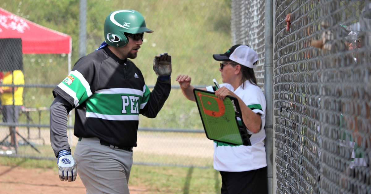 Special Olympics PEI coach Judy Gallant high fives a player on the field.