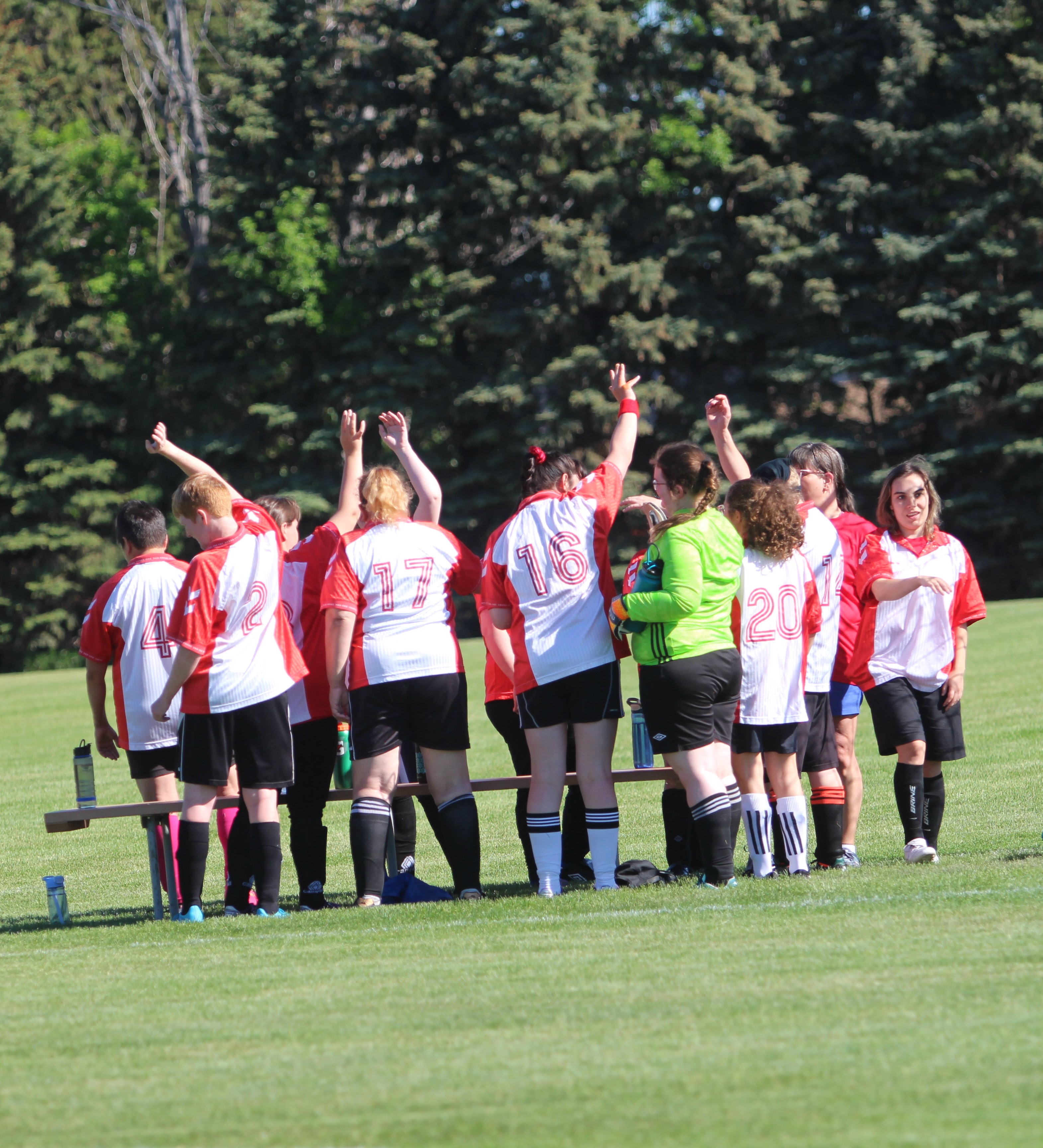 A women's soccer team gathers in a field