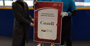 SOBC speed skaters holding a sponsor sign. 