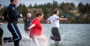 SOBC athletes and Saanich police officers running into cold waters with big smiles