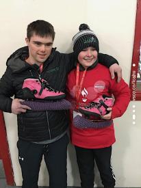 ""Jordan holds up his borrowed skates with Russell Cooper-Landry at Thunder Bay’s Delaney Arena.