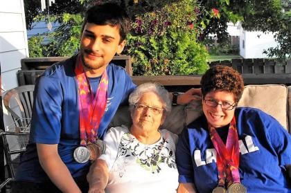 Noella Douglas sits between two Special Olympics Quebec athletes in her backyard.