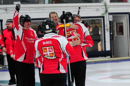 Team NL curling athletes and coaches celebrating and hugging.