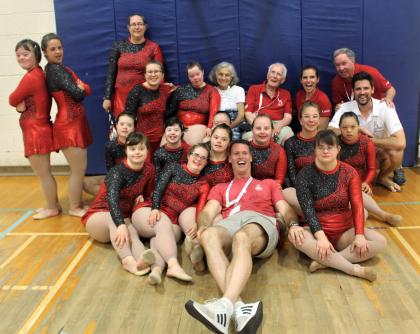 Mark Tewksbury poses for a photo with Special Olympics rhythmic gymnasts.