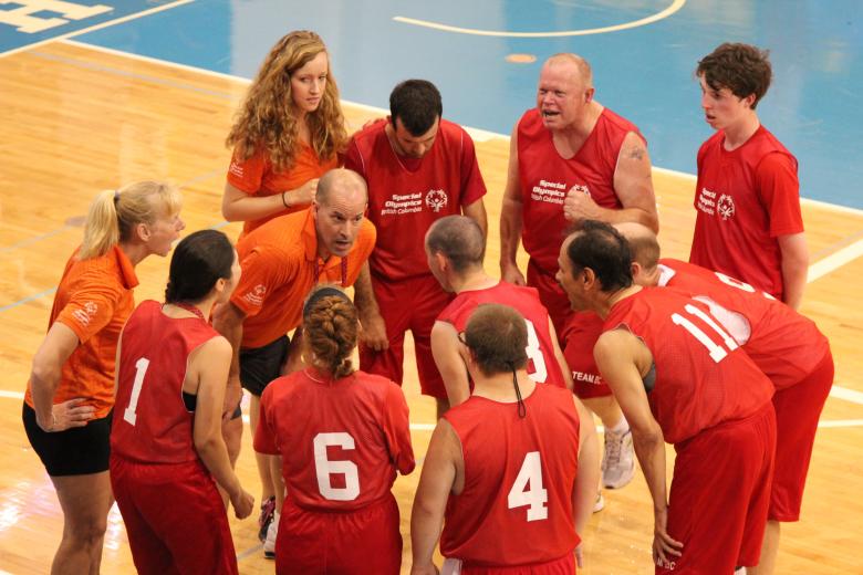 SOBC basketball players huddling around coach