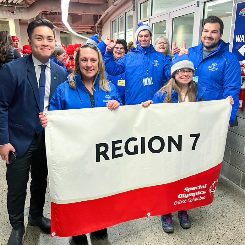 TD representative Evan Choy holding Region 7 banner with SOBC athletes and coaches