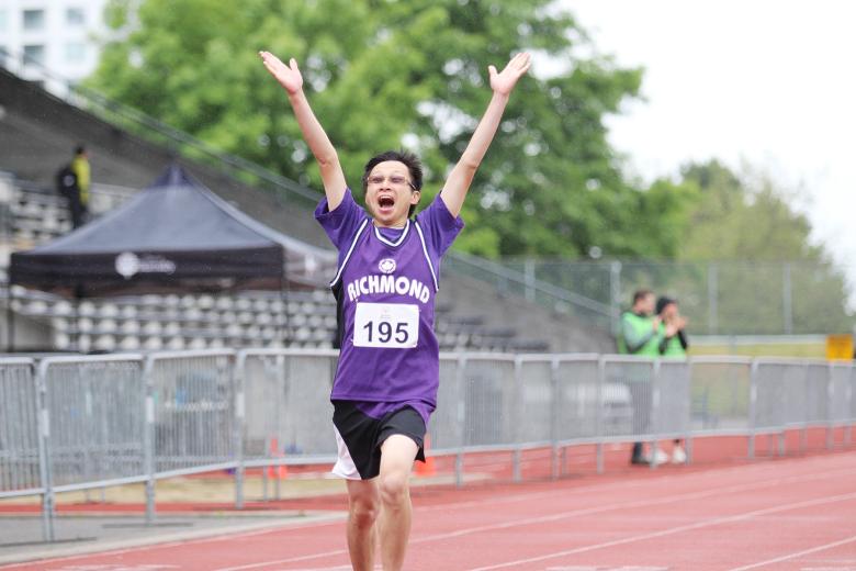 Special Olympics athlete Matthew celebrating at the finish line of a track race
