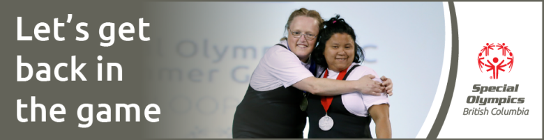 Powerlifting athletes Joanne and Lisa stand on the podium side by side, smiling and embracing each other