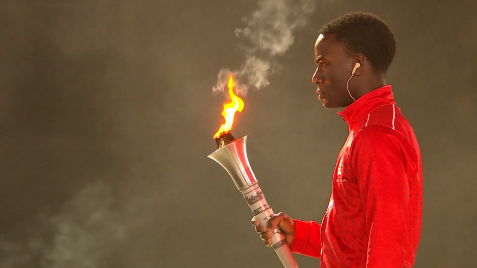 Eddie Nicks holds the flame during Opening Ceremony.