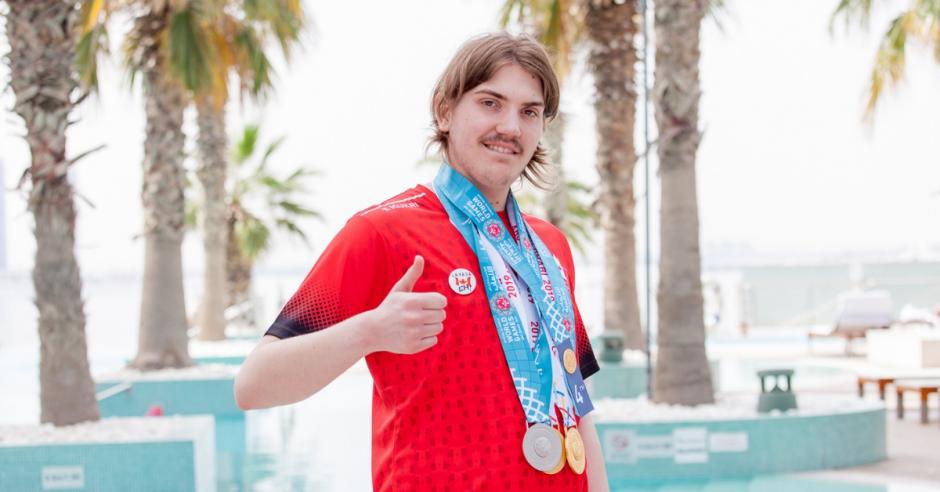 SO Team Canada swimmer Colby Kosteniuk gives the thumbs up while wearing his World Games medals.