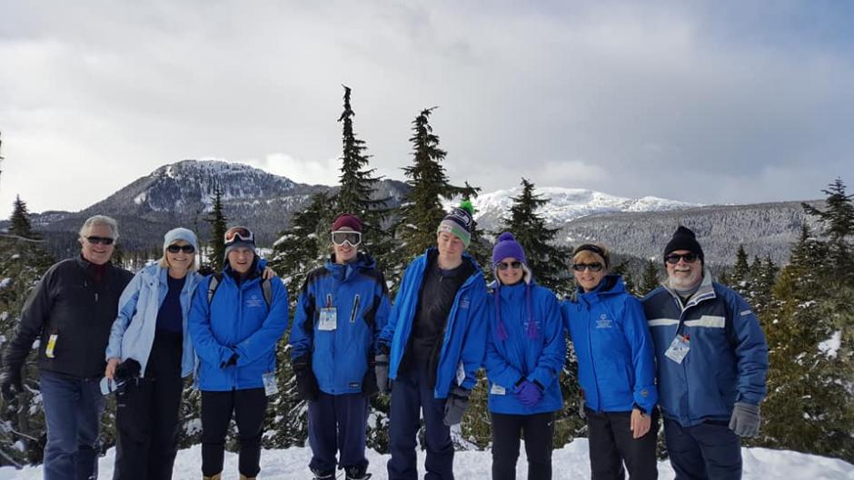 Special Olympics BC - Campbell River snowshoeing athletes and coaches standing on a mountain