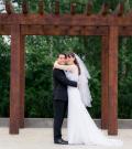 Matthew and Crystal hug on their wedding day while looking into the camera.