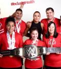 Athletes stand for a photo with WWE star Becky Lynch