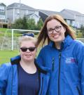 Volunteer Melissa Tobin smiles for a photo with an athlete on a soccer field.