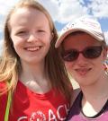 A young volunteer takes a selfie with an athlete on a sunny day