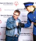 Kristi MacKay, dressed in her uniform, fist bumps an athlete at an event.