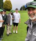 Drew group selfie with four golf athletes on golf course