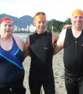 Peter with two other SOBC athletes, all in swimsuits at beach in Vancouver