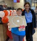 Danielle holding Choose To Include poster with Tim Hortons employee