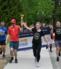 Law enforcement members and SOBC athletes running with LETR banner and torch