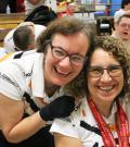 "An athlete hugs coach Susan Altomare from behind at a bowling alley."