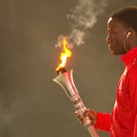 Eddie Nicks holds the flame at Opening Ceremony.