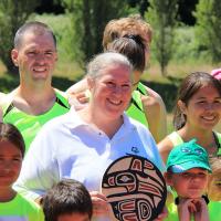 Angela Behn receiving the 2019 SOBC Howard Carter Award surrounded by athletes at the SOBC - Nanaimo athletics meet on June 15.