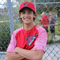 Coach Blake Fenwick poses for a photo at the baseball diamond.