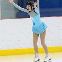 Moriah on the ice with her hands up