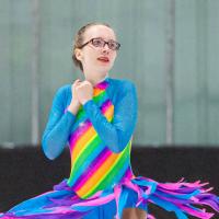 Jordyn Flamma spins on the ice in her rainbow dress.